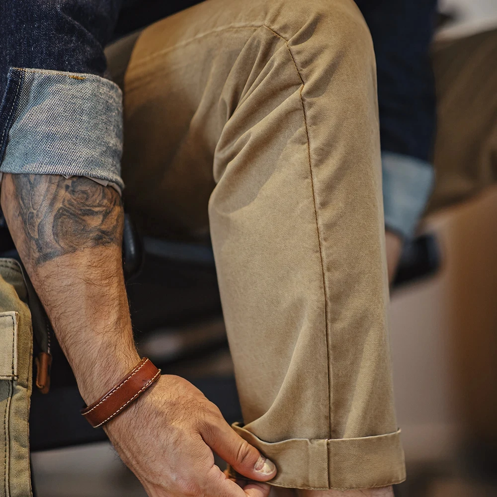 Maden presenta pantalones casuales vintage para hombre en color caqui, hechos de sarga de algodón pesado. Corte recto clásico, perfecto para el trabajo en otoño, con cierre de cremallera que brinda comodidad y estilo